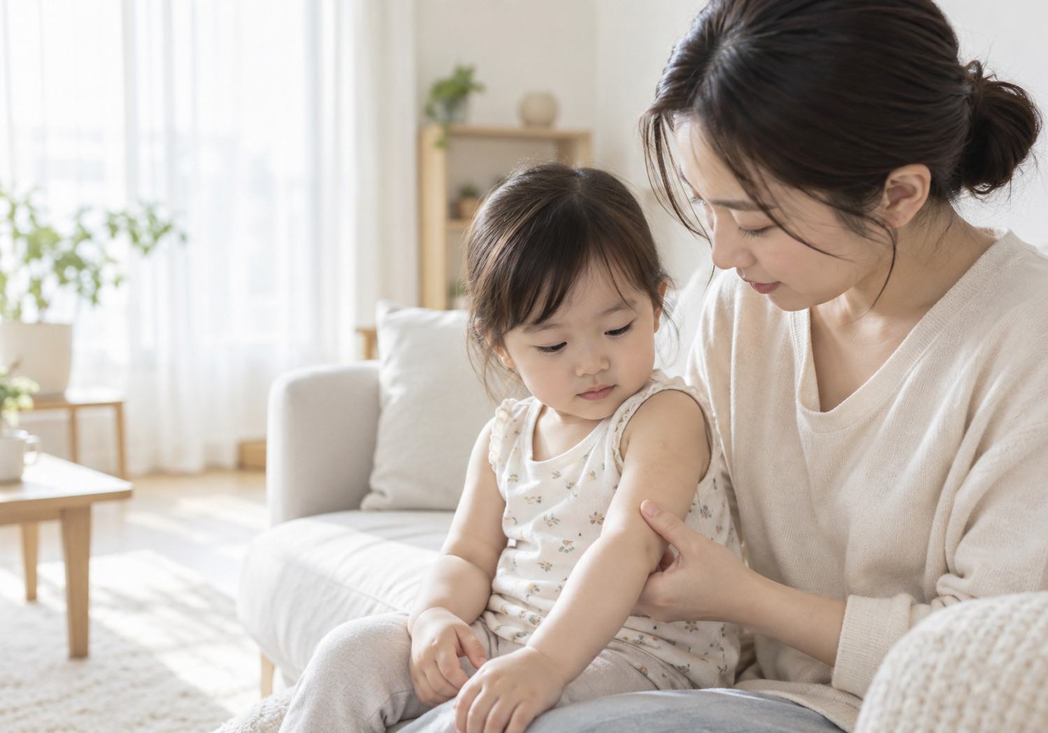 강남 아기 물사마귀 – 엄마가 어린아이의 팔 피부를 살펴보는 장면