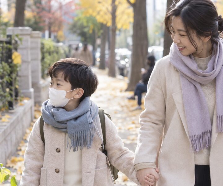 목도리와 마스크로 찬 공기를 막고 걷는 아이와 보호자