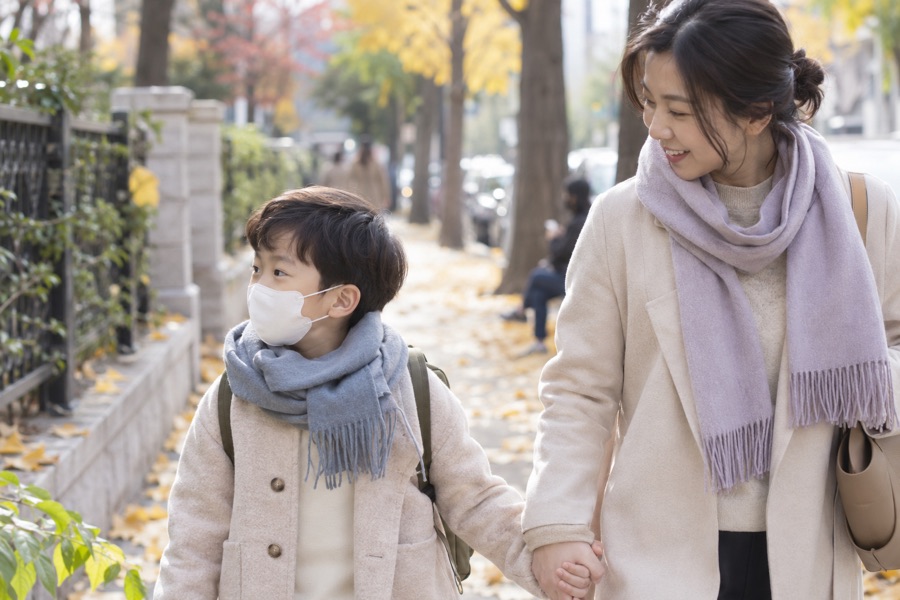 목도리와 마스크로 찬 공기를 막고 걷는 아이와 보호자