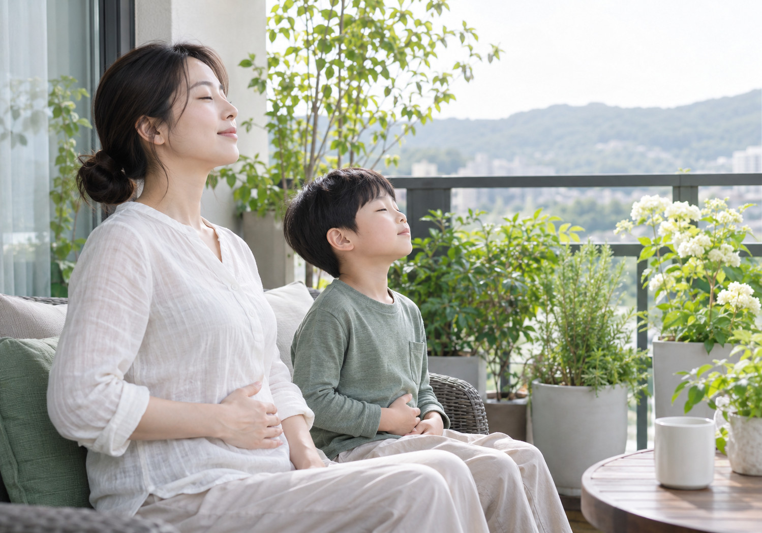 성북 입으로 숨쉬는 아이 – 엄마와 남자아이가 테라스에 앉아 눈을 감고 배에 손을 얹은 모습