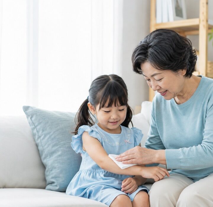 송도 두드러기 – 할머니가 부드러운 수건으로 여자아이의 팔을 닦아주는 장면