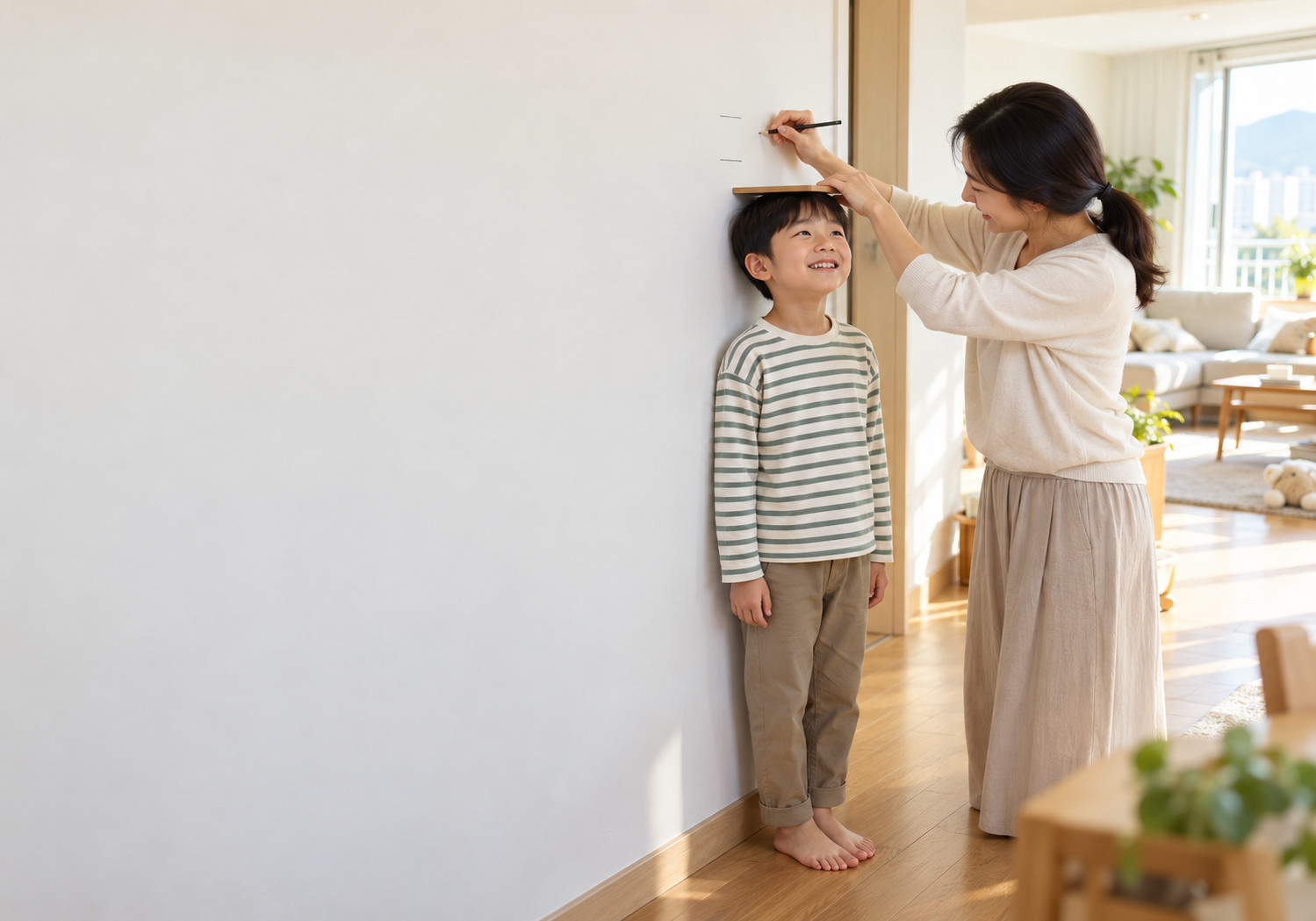 광주 아이 키 성장속도 – 엄마가 벽 앞에 선 남자아이의 머리 위에 판을 대고 연필로 키를 표시하는 모습