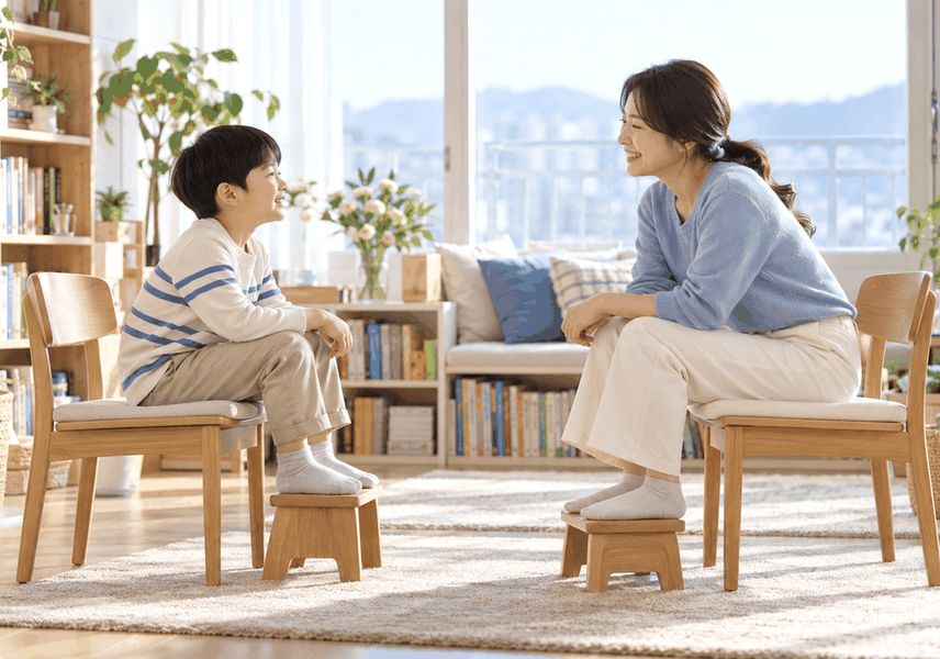 아이가 발판에 발을 올리고 편안하게 변기에 앉는 연습을 하는 모습