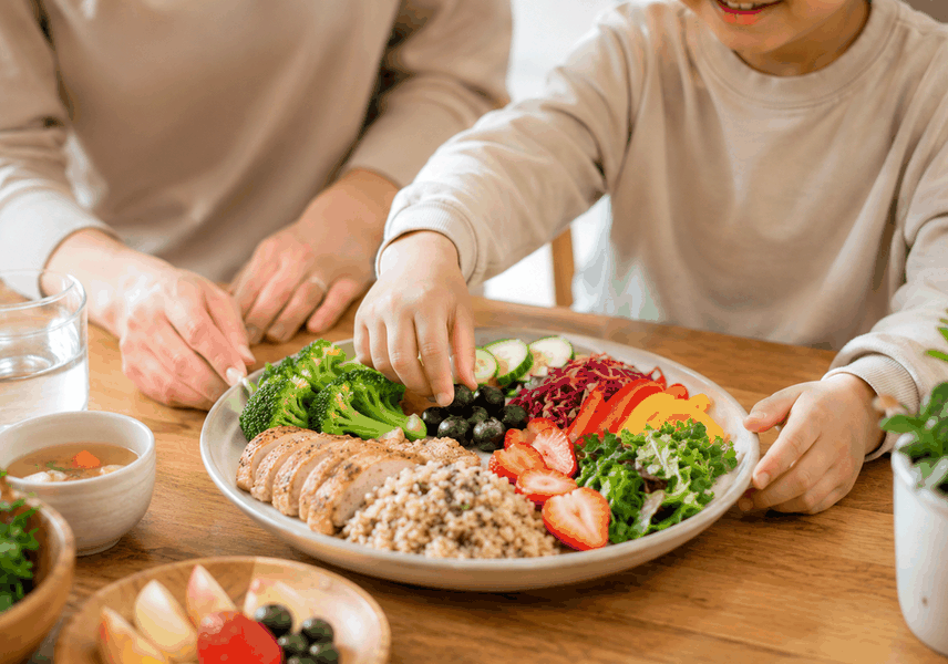 전주 소아비만성장 – 아이가 채소·과일이 담긴 건강한 접시로 손을 뻗는 모습